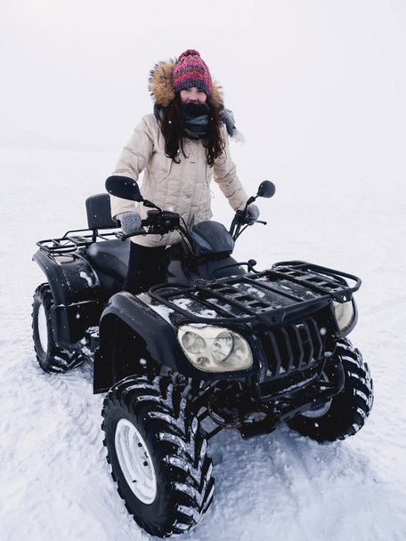 Meisje in ATV quad fiets. Wintersneeuwveld - Foto, afbeelding