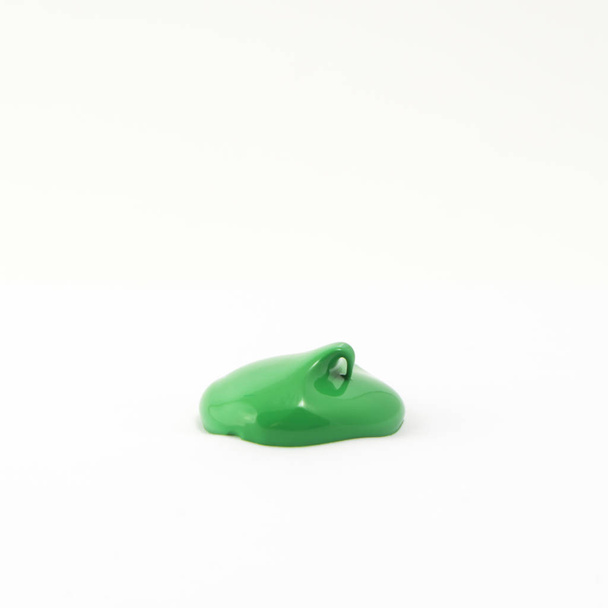 a drop of acrylic green color on a white surface - Photo, Image