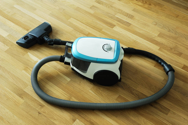 blue vacuum cleaner on the floor - Фото, изображение