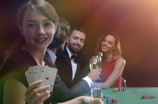 Portrait of the female gambler at the poker table with cards - Photo, Image