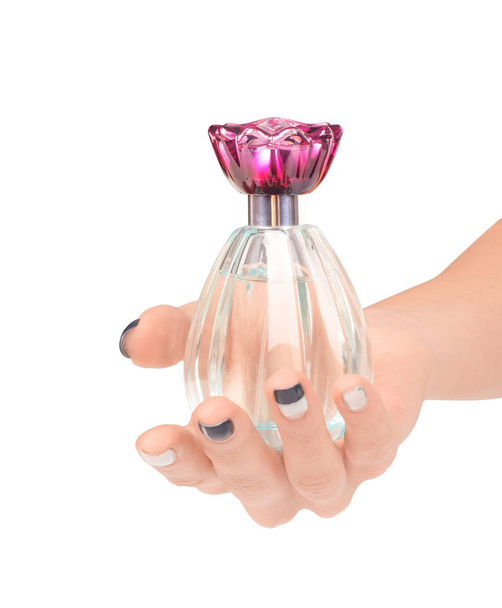 Beautiful female hand holding the bottle of perfume isolated on  - Фото, зображення