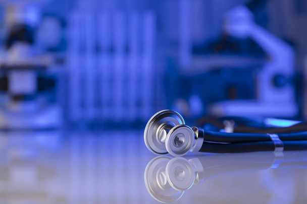 Gezondheidszorg, medische concept. Stethoscoop, Microscoop, laboratorium glaswerk. Blauwe achtergrond. - Foto, afbeelding