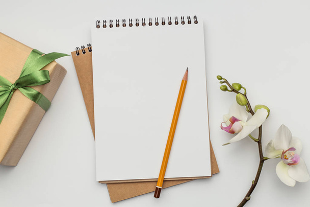 Notizbuch auf weißem Tisch mit Geschenk und Bleistift - Foto, Bild