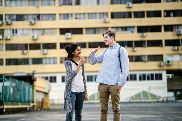 Portrait of a young attractive tourist couple standing in the daytime. The female is indian and male caucasian.They are both dressed casually  - Photo, Image