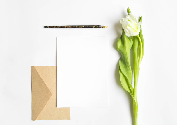 Letter, envelope and tulip on white background. Invitation card, or love letter. Top view, flat lay - Photo, Image