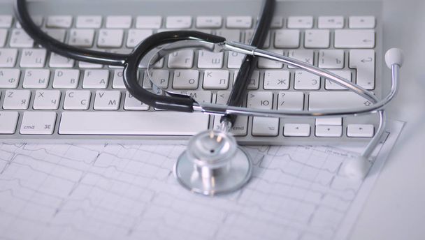Egy orvosi sztetoszkóppal közelében egy laptop, tábla, fehér - Fotó, kép