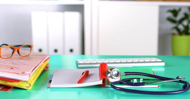Lékaři pracovního prostoru pracovní stůl s pacienty vypouštění prázdné papírové podobě, lékařský předpis, stetoskop na stole - Fotografie, Obrázek