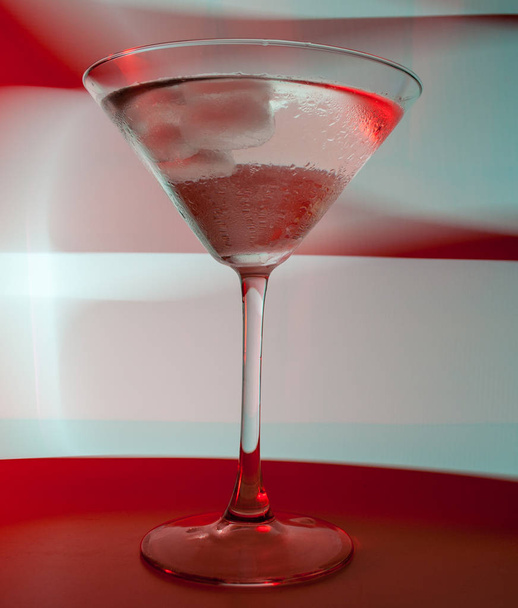 A martini glass with a cocktail in beautiful light of different colors - Foto, Bild