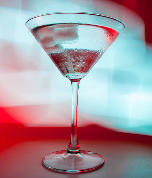 A martini glass with a cocktail in beautiful light of different colors - Foto, immagini