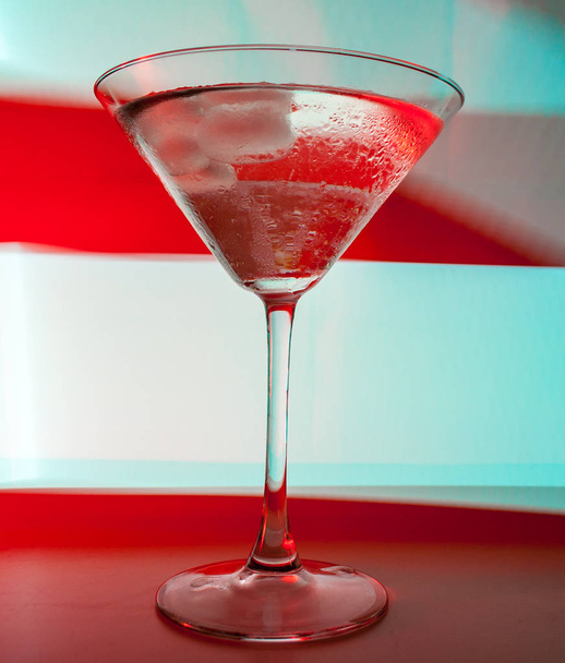 A martini glass with a cocktail in beautiful light of different colors - 写真・画像