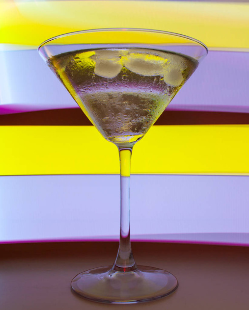 A martini glass with a cocktail in beautiful light of different colors - Fotografie, Obrázek