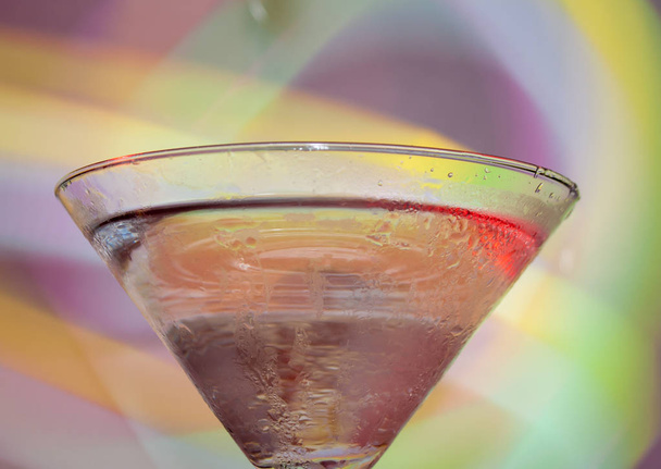 A martini glass with a cocktail in beautiful light of different colors - Valokuva, kuva