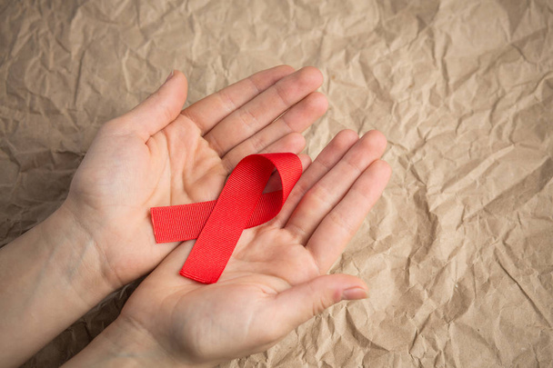 SIDA cinta roja en la palma, sobre el fondo de la artesanía, cinta hiv en kra
 - Foto, imagen