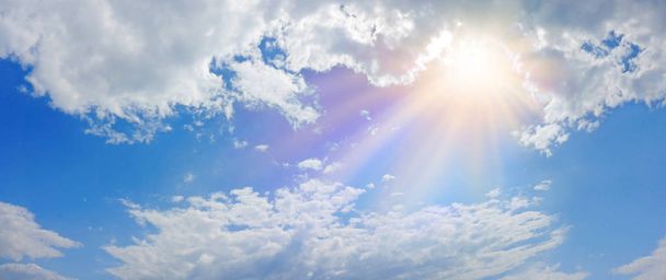 wundersame himmlische Licht-Panorama-Fahne - weiter blauer Himmel, flauschige Wolken und eine schöne warme orange-gelbe Sonne, die eine heilige Einheit darstellt  - Foto, Bild