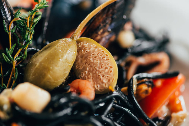 επιλεκτική εστίαση του γκουρμέ Σπαγγέτι με μελάνι σουπιάς, καλαμάρι και μύδια με χταπόδι - Φωτογραφία, εικόνα