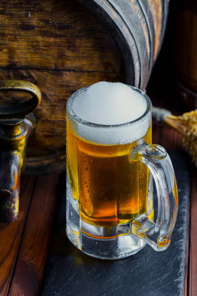 Ελαφρύ αφρού μπύρα σε ένα ποτήρι σε ένα παλιό φόντο - Φωτογραφία, εικόνα