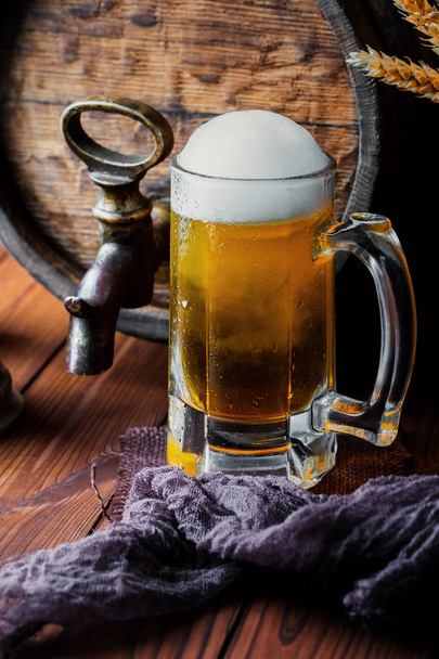Light foam beer in a glass on an old background - Фото, изображение