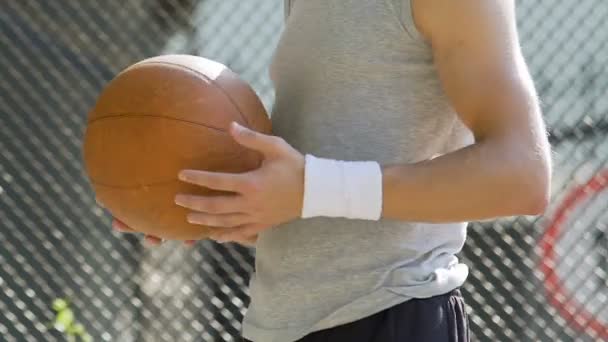White handsome man spinning basket ball on finger, summer activities, balance - Imágenes, Vídeo