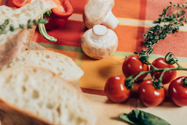 fresh ripe cherry tomatoes, mushrooms and sliced bread on table napkin - Photo, image