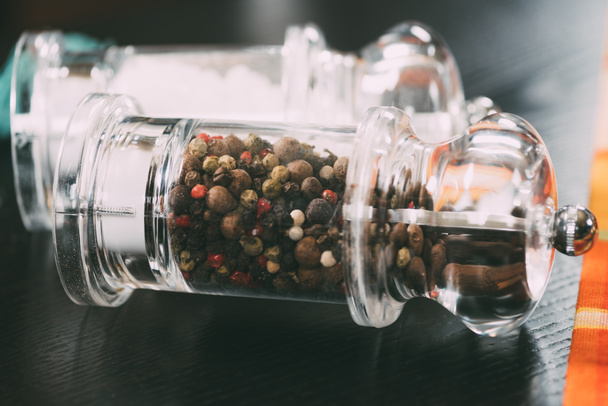 selective focus of salt and peppercorns in glass containers - Foto, Imagen