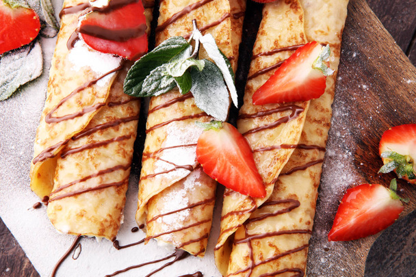 Crepes with jam, berries and sugar powder. Homemade pancakes, de - Photo, Image