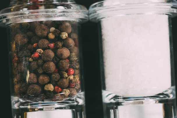 close-up view of salt and peppercorns in glass containers - Photo, Image