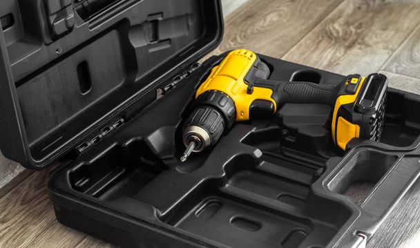 hand electric tool: a yellow screwdriver in a molded black box - Photo, image