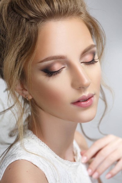 Pretty bride with a gentle makeup on a gray background. - Fotó, kép