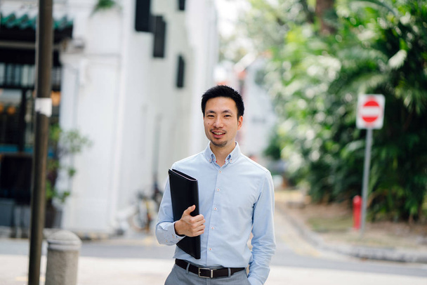  young professional (lawyer, banker, accountant, etc). He is smiling confidently in the day and professionally dressed in a shirt  - 写真・画像