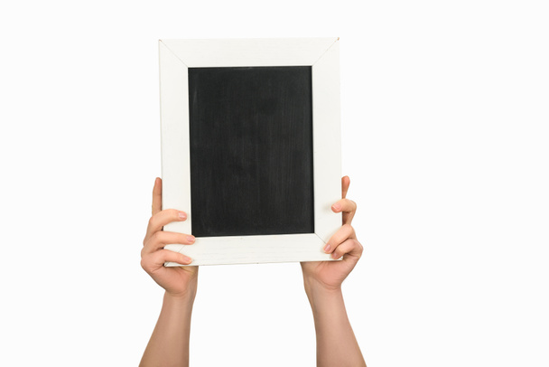 白で隔離空の黒板を保持している女性のトリミング ビュー - 写真・画像