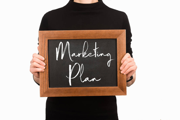 Частковий вигляд жінки, що тримає дошку з написом маркетингового плану ізольовано на білому
 - Фото, зображення