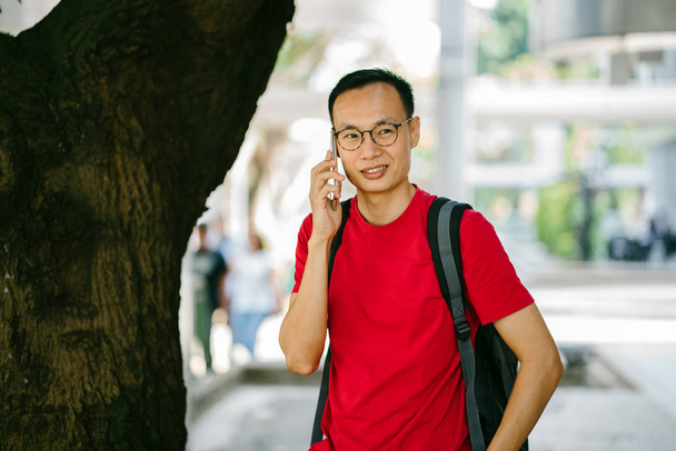 middle-aged Asian man with phone in city - Foto, Bild