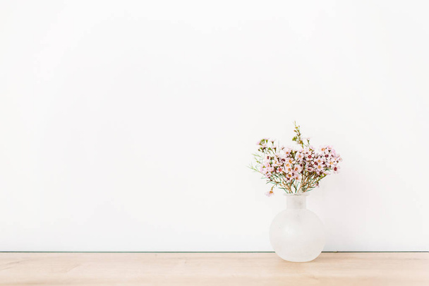 Flores silvestres frente a la pared blanca. Composición mínima
. - Foto, imagen