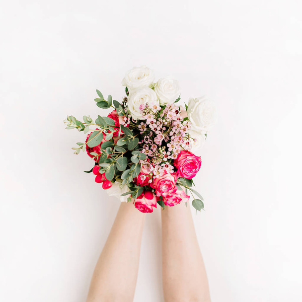 Жінка тримає букет з троянд, евкаліптової гілки, диких квітів. Пласка лежала, вид зверху концепція весільного фону
. - Фото, зображення