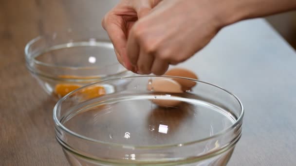 Female hands breaking an egg and separating yolk from white. - Video, Çekim