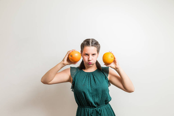 Young woman makes expressions with grapefruits - Foto, immagini