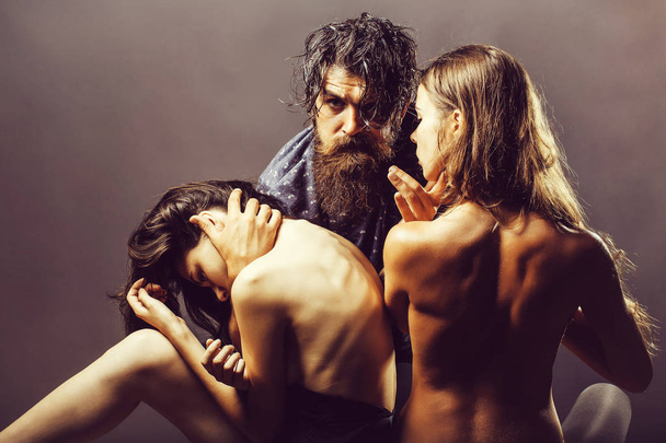 handsome bearded man with beard and pretty girls with naked back posing has bare sexy body in studio on gray background - Fotografie, Obrázek