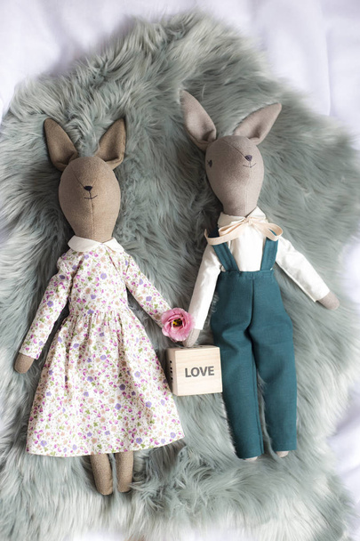 Gros plan de poupées en chiffon faites main. Poupées de lapin à la main de Pâques placées sur la fourrure
  - Photo, image