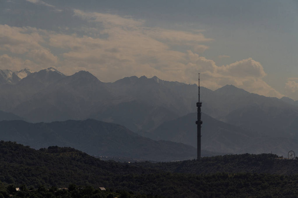 Vista sobre a cidade em direção às montanhas além, com o reboque de comunicações
 - Foto, Imagem