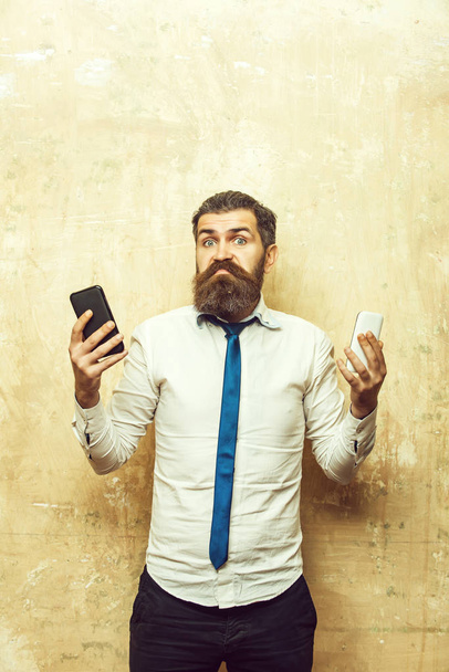 hipster or bearded man compare mobile phone and smartphone - 写真・画像