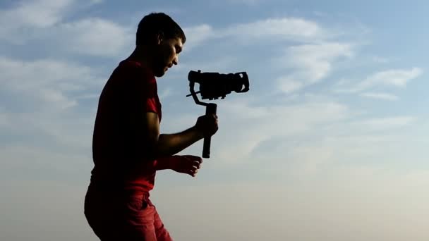 Jonge cameraman schiet iemand met een steadicam in slo-mo - Video