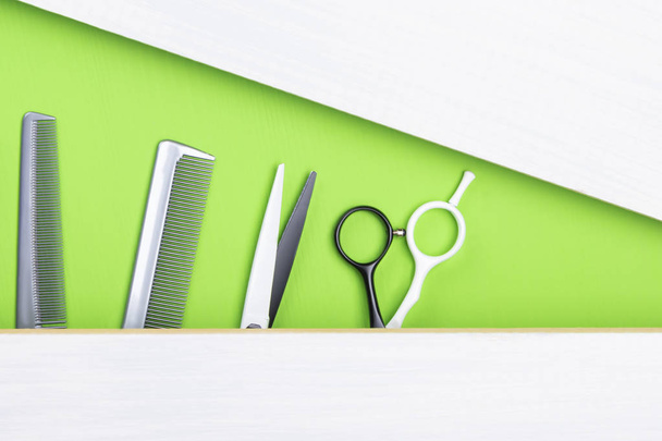 idea of a green and gray background with a comb and scissors for a hairdresser - Foto, afbeelding
