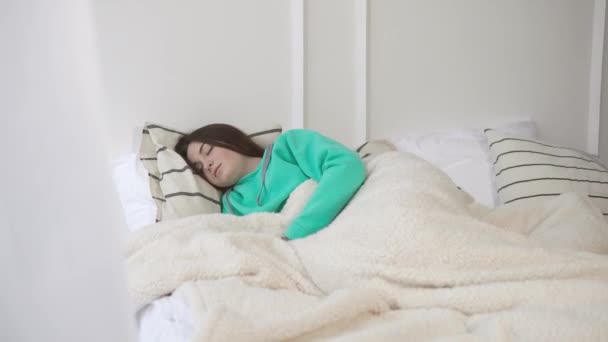 Молодая девушка спит в своей постели утром и просыпается
 - Кадры, видео