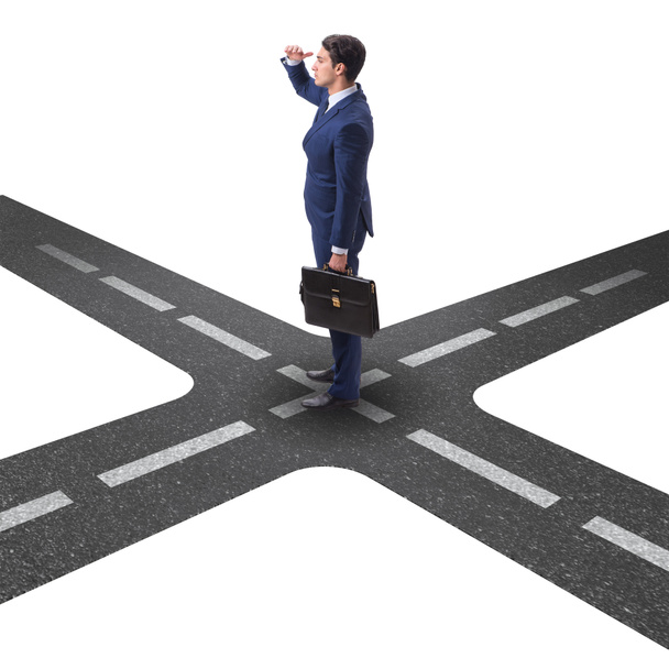 Young businessman at crossroads in uncertainty concept - Photo, Image