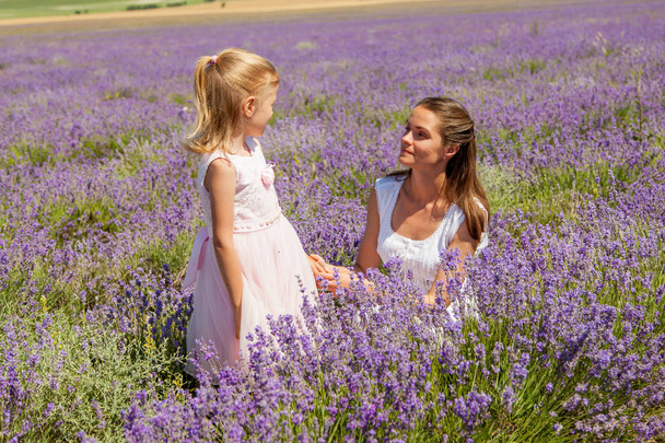Girl with a child in a field of lavender - Фото, изображение