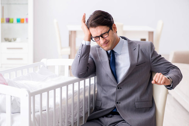Young businessman trying to work from home caring after newborn  - Photo, Image