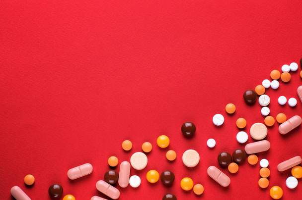 Pile of medical capsules pills in red and white color on red background,top view for copy space - Fotoğraf, Görsel