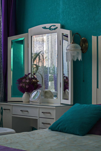 Interieur 2. Kaptafel, vaas, spiegel, Schans. Slaapkamer in turquoise tinten. - Foto, afbeelding