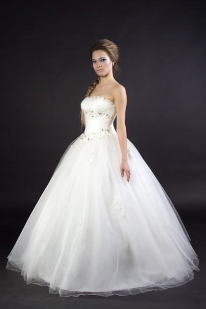 Young beautiful girl in a wedding dress on a dark background - Zdjęcie, obraz