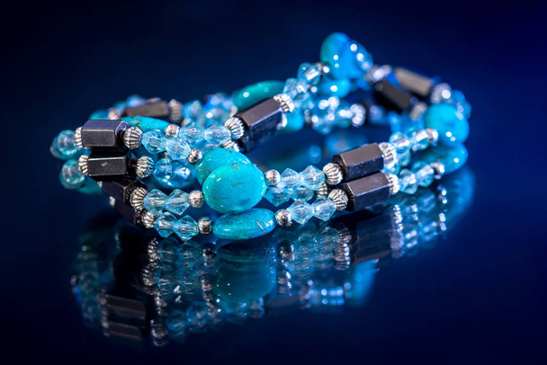 pulsera mezcla piedras preciosas y perlas aisladas en azul oscuro
. - Foto, imagen